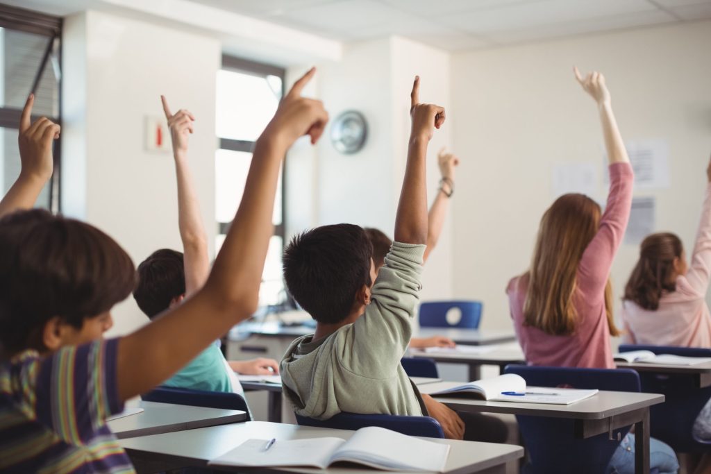 school kids raising hand in classroom 2021 08 28 16 44 12 utc scaled 1