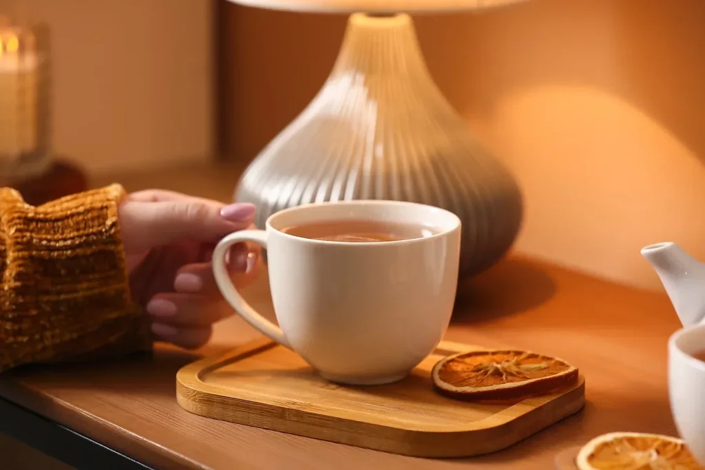 Hand holding a cup of tea in a cafe showing why tea in Malaysia remain popular among customers who prefer tea bags 1