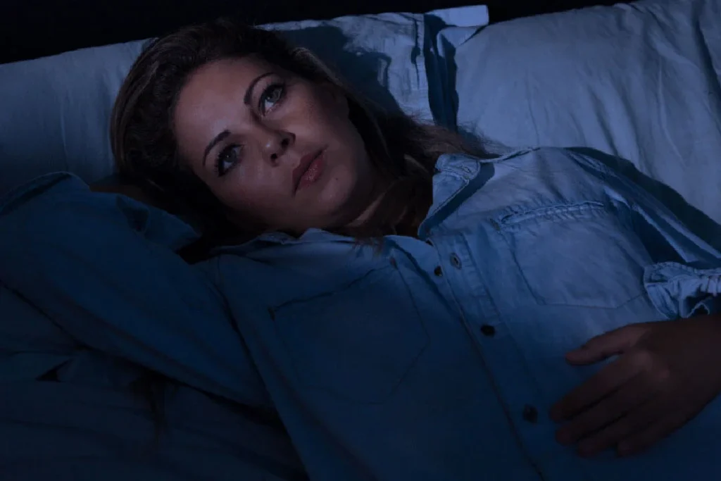 Woman lays awake in bed with insomnia
