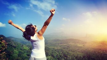 young woman open arms seaside