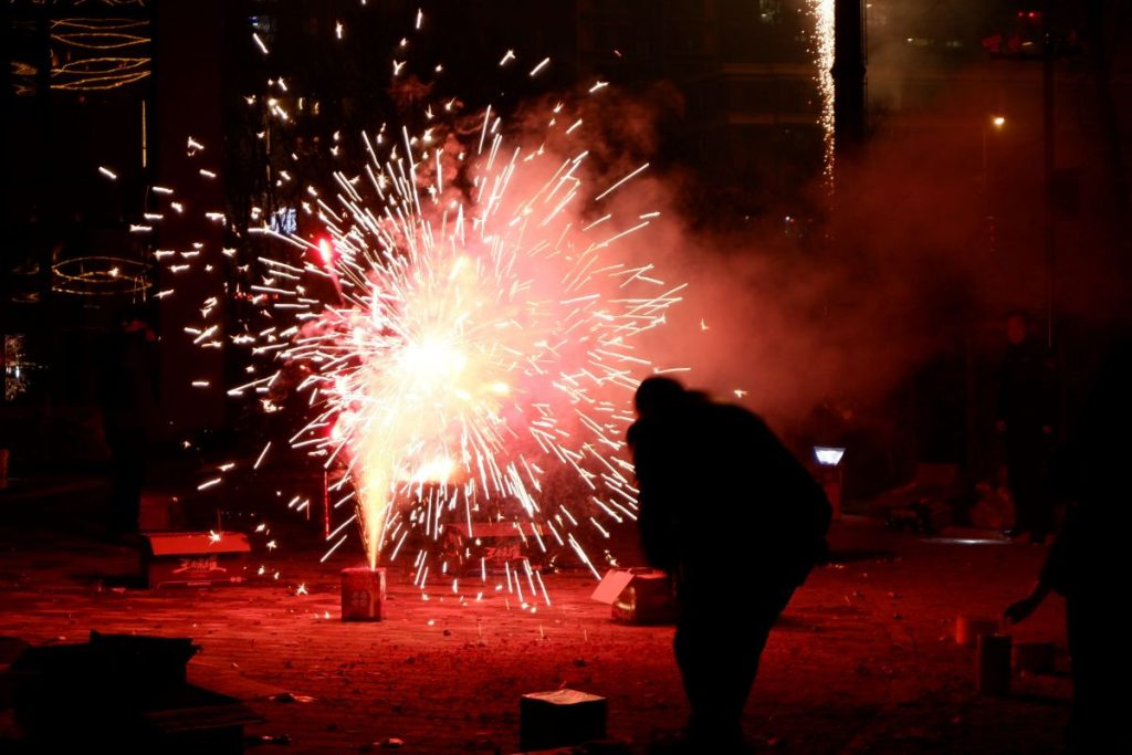 a person standing under a fire with fireworks in t 2023 11 27 05 03 21 utc